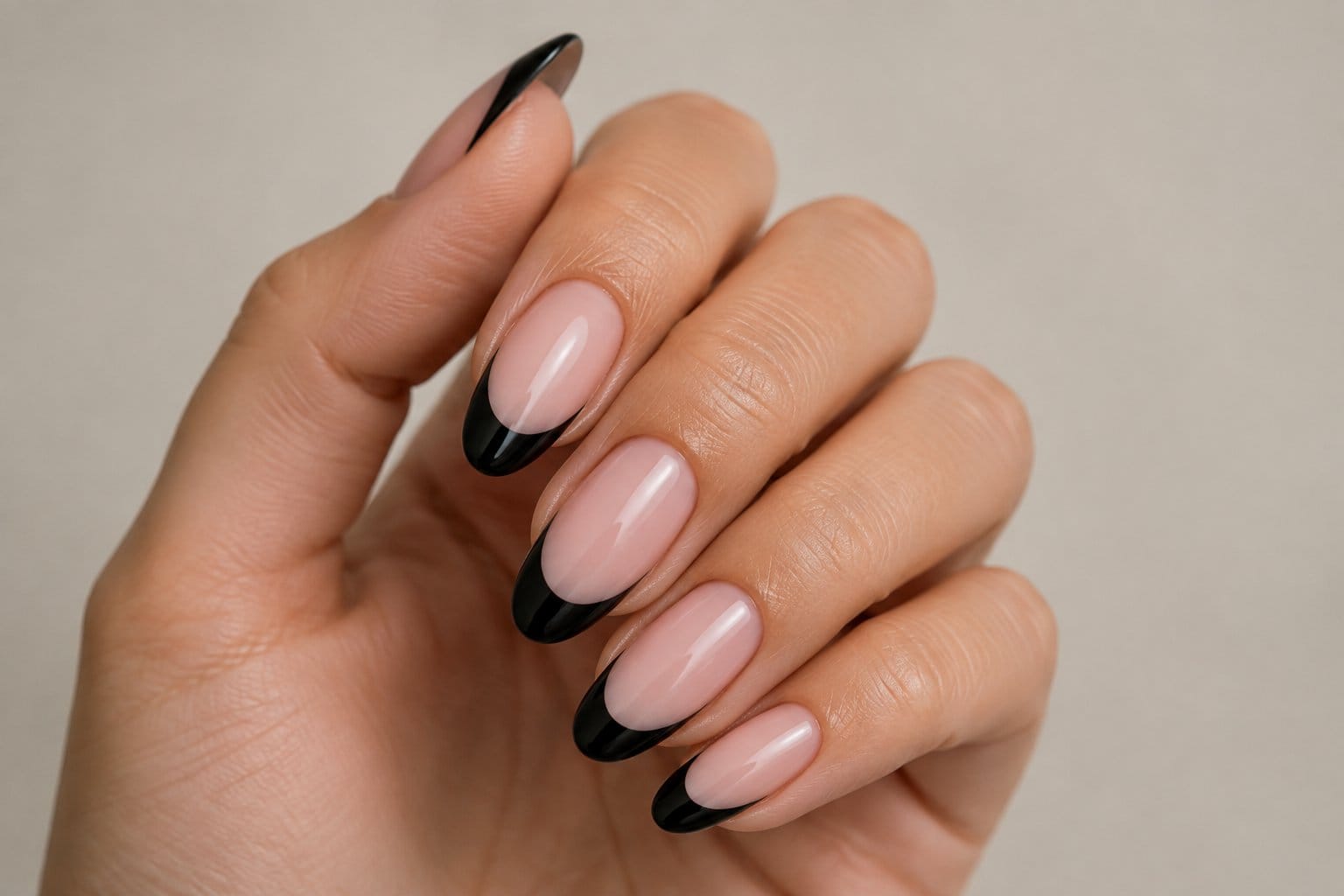 A hand with glossy black French-tip nails.