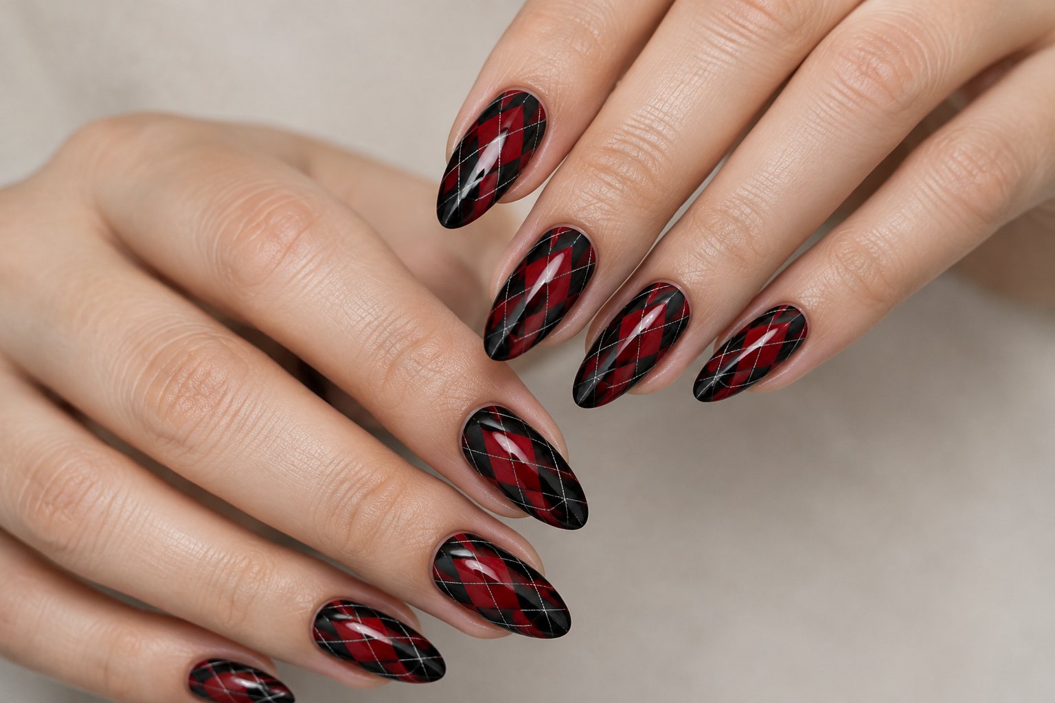 Hands with black and red argyle-patterned nails.