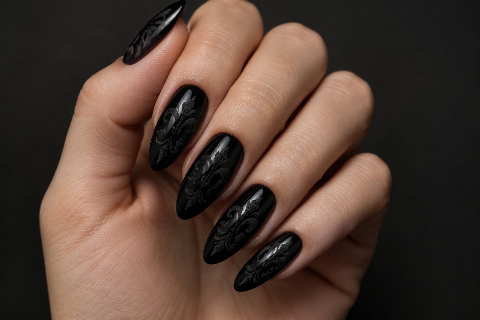 A hand with long black nails decorated with intricate patterns.